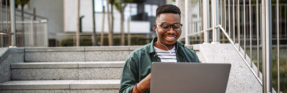 Image of a smiling male interacting with his computer